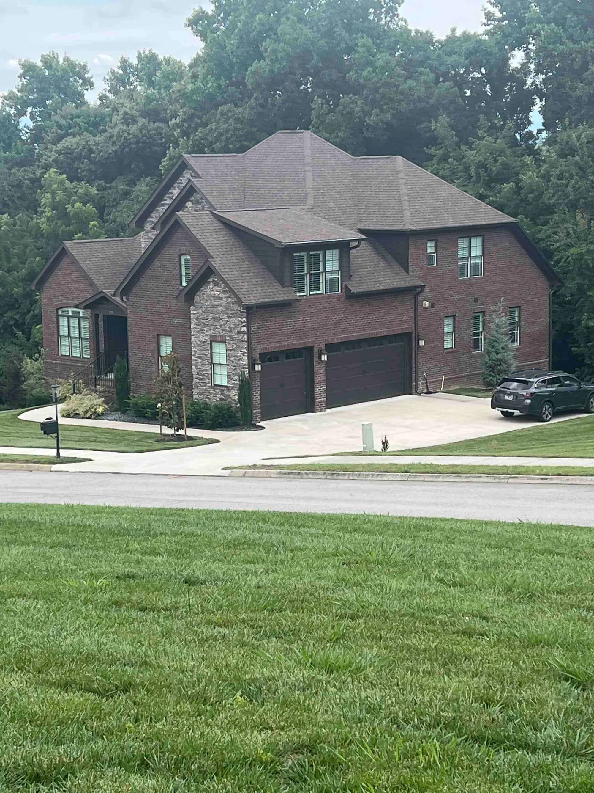 Two-story brick home with a shingle roof during a contractor visit in Farragut