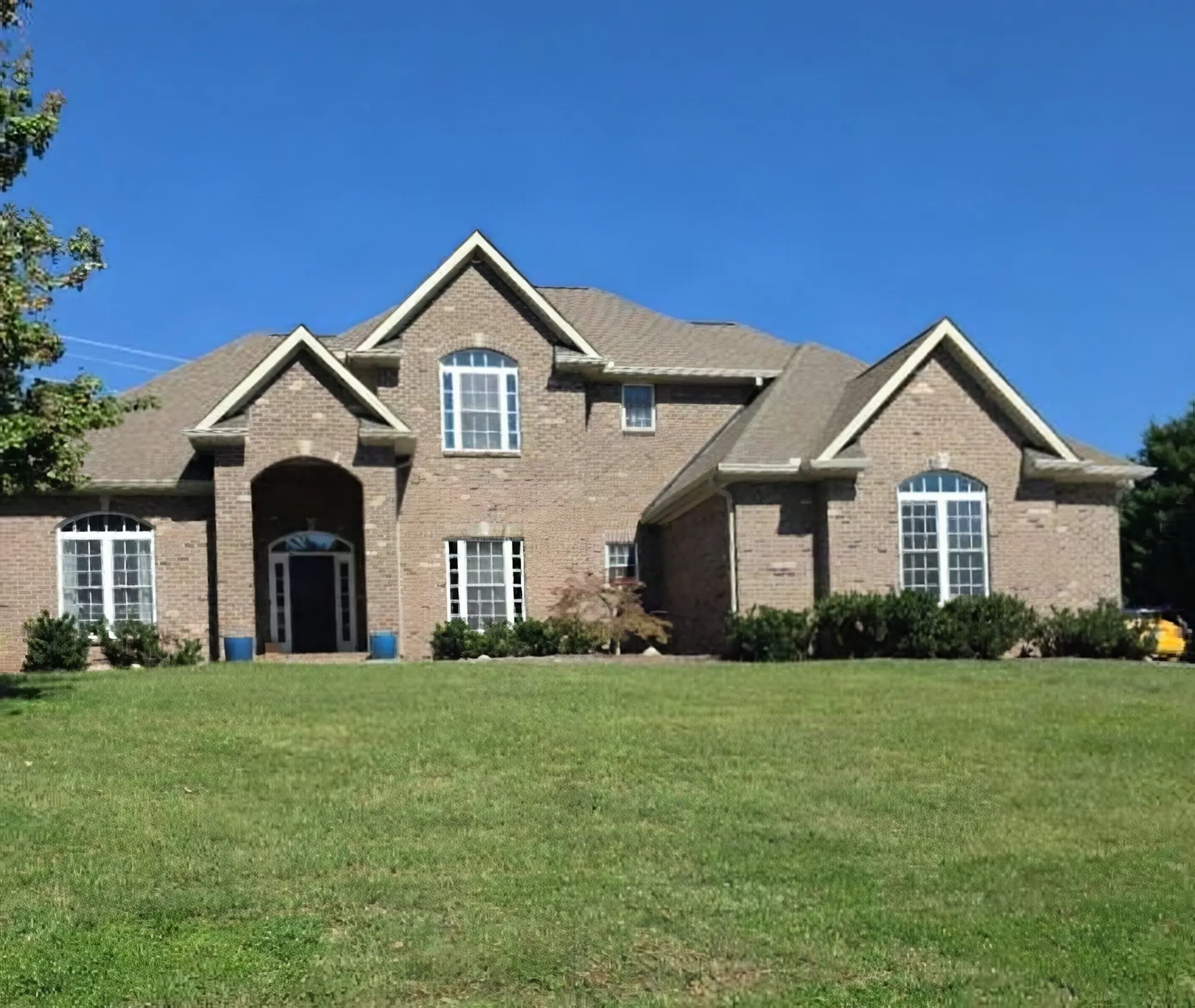Two-story brick home with a shingle roof in Knoxville, visited while answering a homeowner's roofing contractor questions